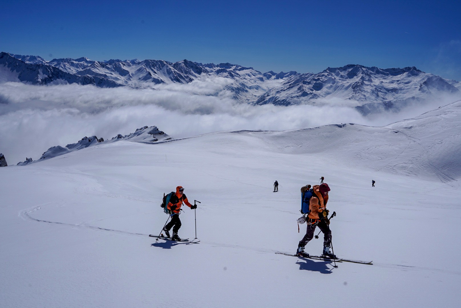 Skieurs de randonnée sur un plateau glaciaire au-dessus d'une mer de nuages, Dammastock