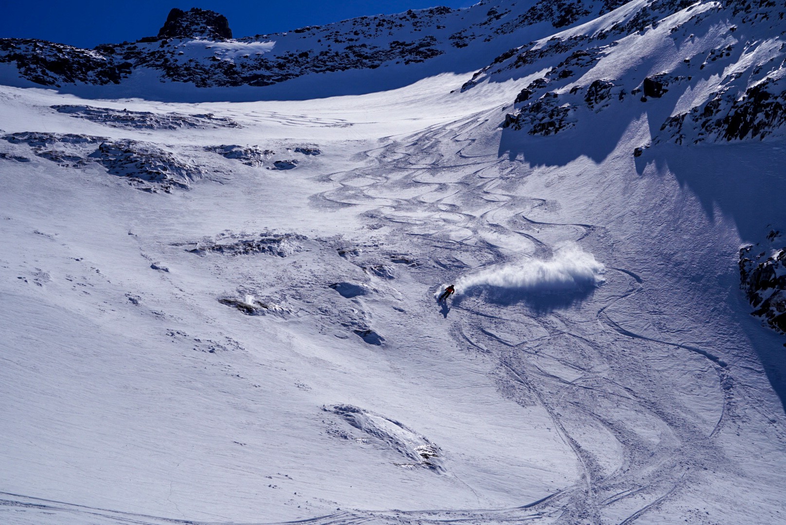 Skieur soulevant un nuage de poudreuse dans une grande pente enneigée, Dammastock