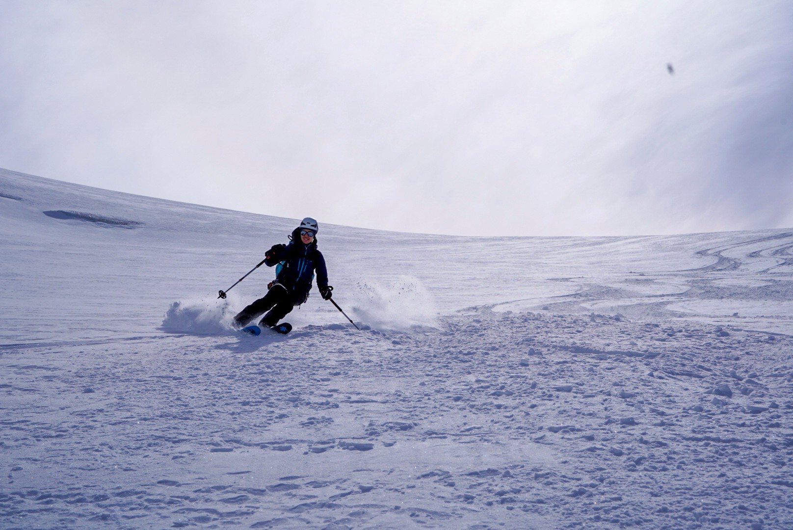 Skieur dans un nuage de poudreuse sur un large plateau glaciaire, Dammastock