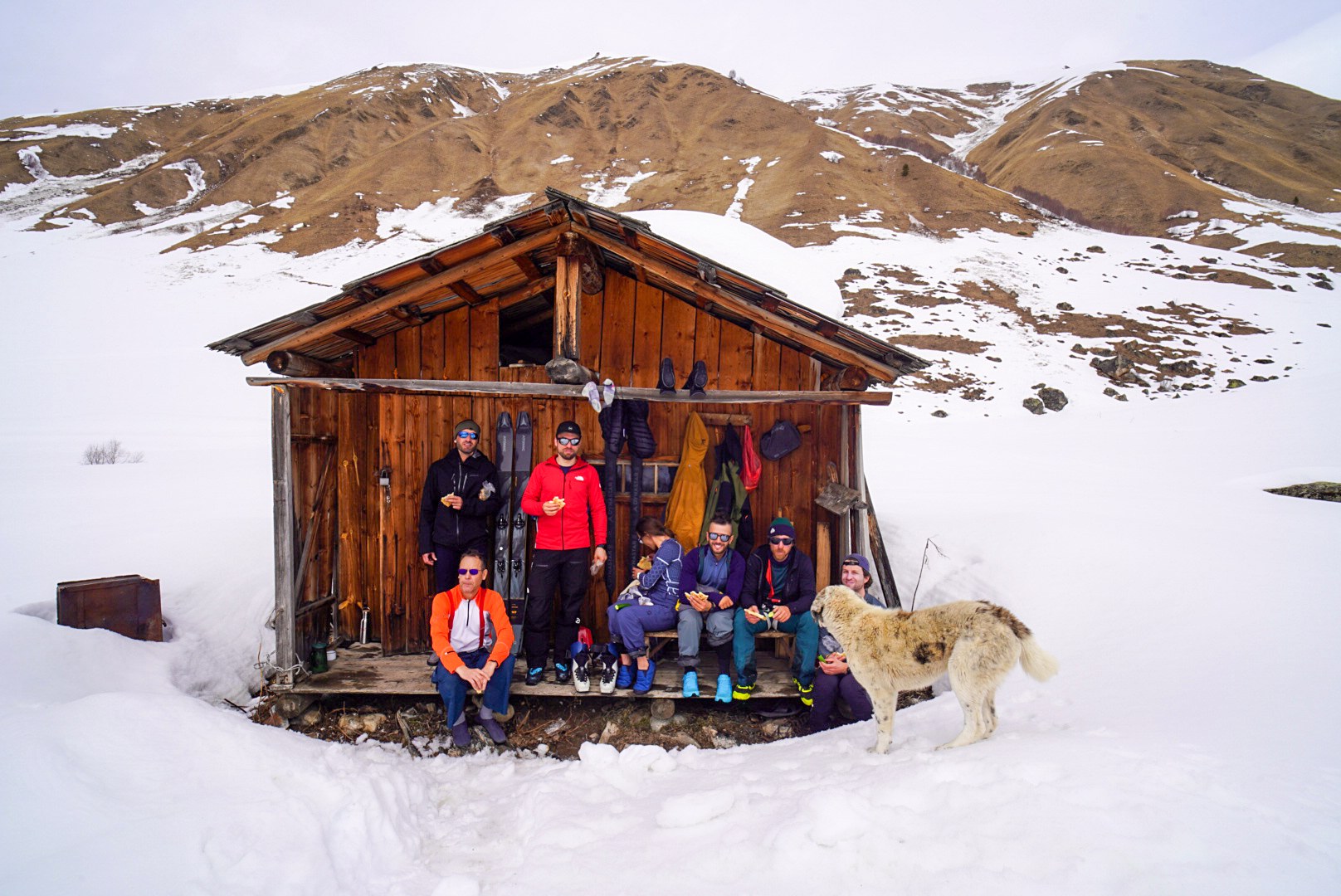 Skieurs rassemblés devant un petit abri enneigé, secteur d’Adishi et du Tetnuldi, pendant une traversée à ski en Haute-Svanétie.