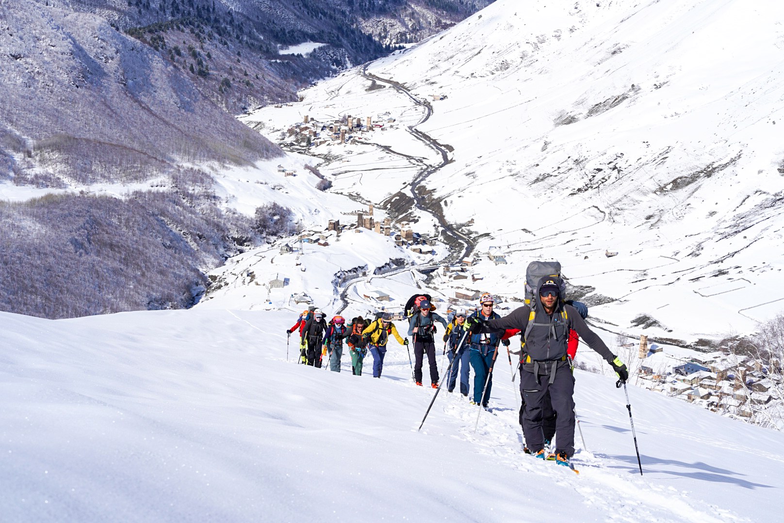 Groupe progressant skis aux pieds, Ushguli, au pied du Shkhara, pendant une traversée à ski en Haute-Svanétie.