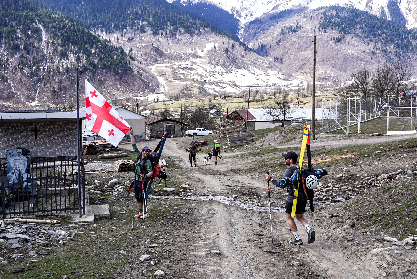 Skieurs passant entre les maisons et les animaux, vallée de Becho et Mazeri, pendant une traversée à ski en Haute-Svanétie.