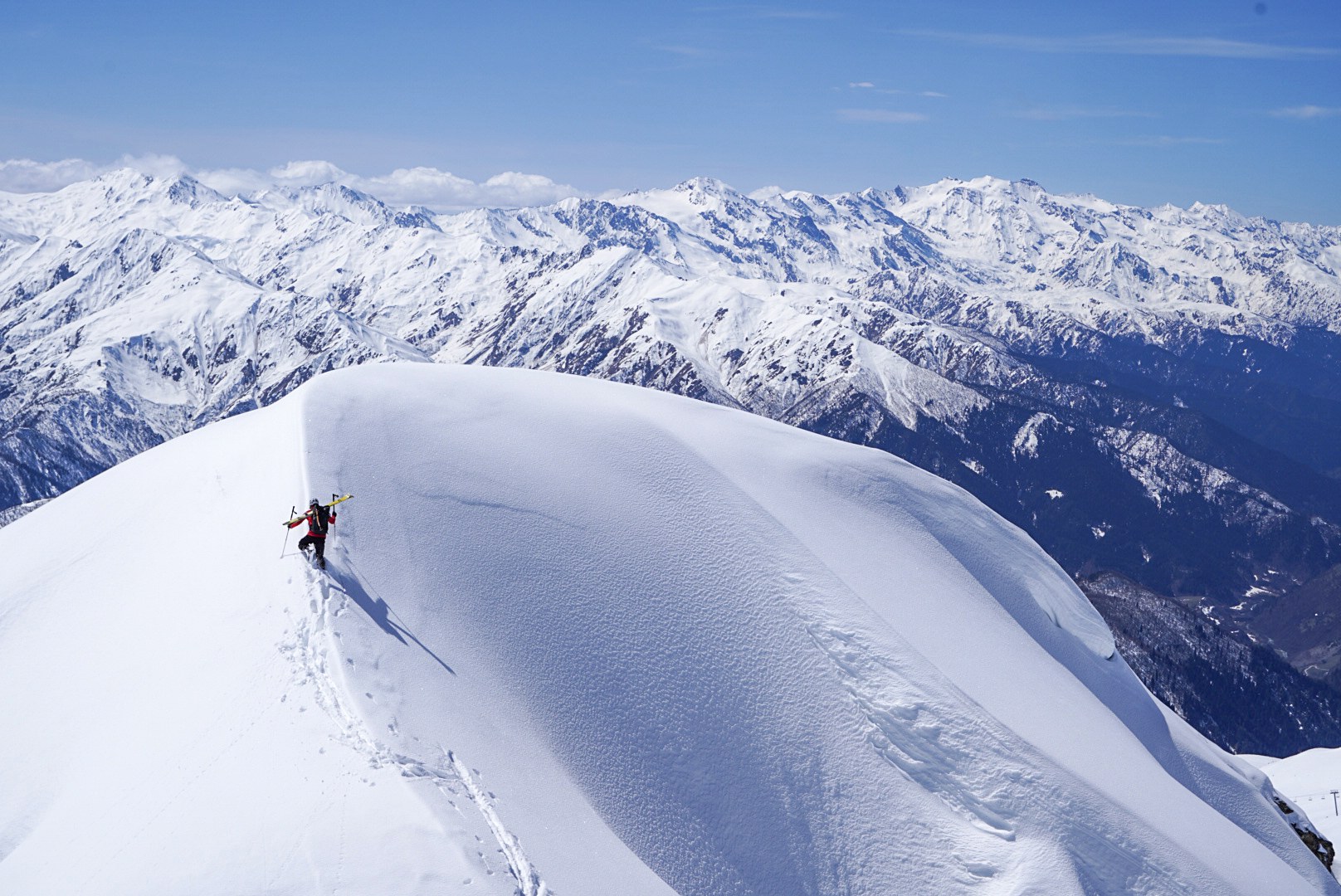 Skieur avançant sur une arête panoramique, secteur d’Adishi et du Tetnuldi, pendant une traversée à ski en Haute-Svanétie.