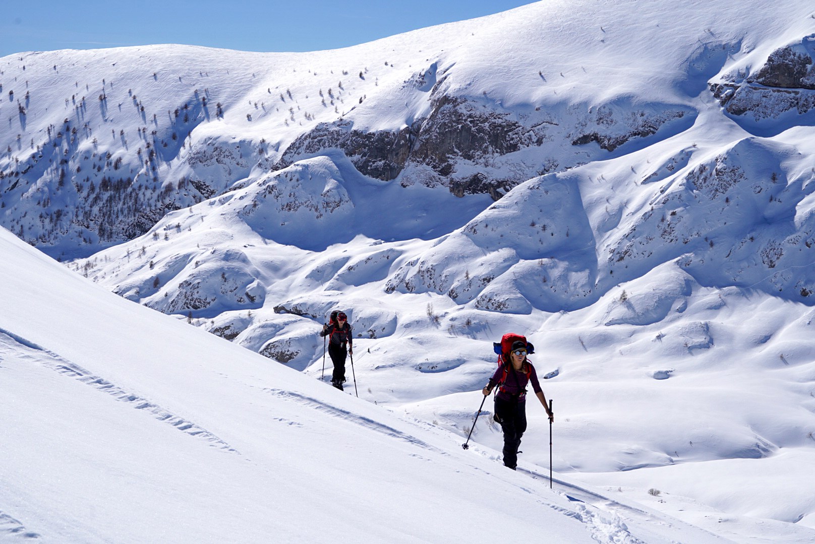 Deux skieurs avançant au milieu de reliefs sculptés par la neige, vallée de Becho, vers le massif de l’Ushba, pendant le voyage à ski en Géorgie.