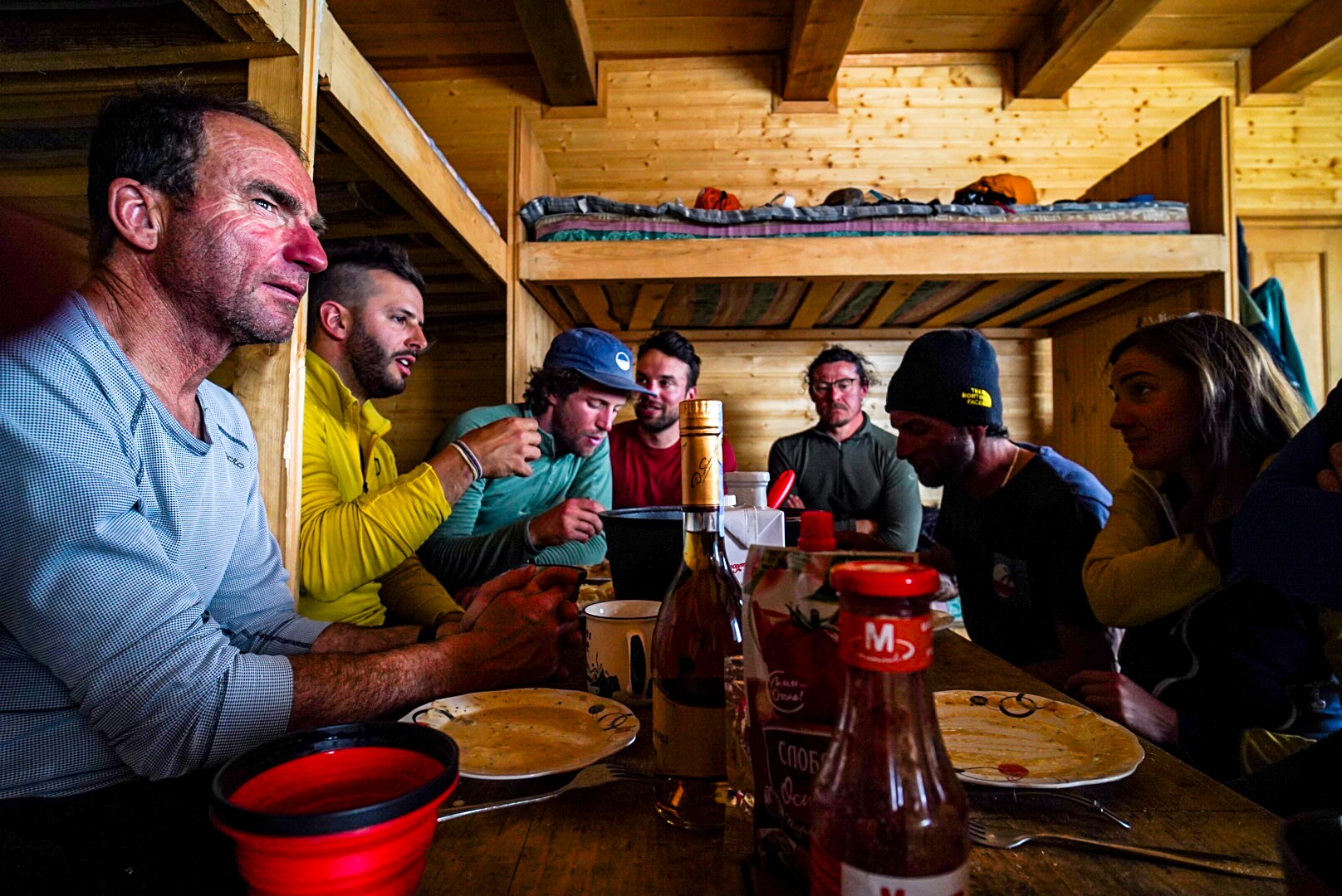 Compagnons levant leurs verres autour de la table, secteur de Mestia, pendant une traversée à ski en Haute-Svanétie.