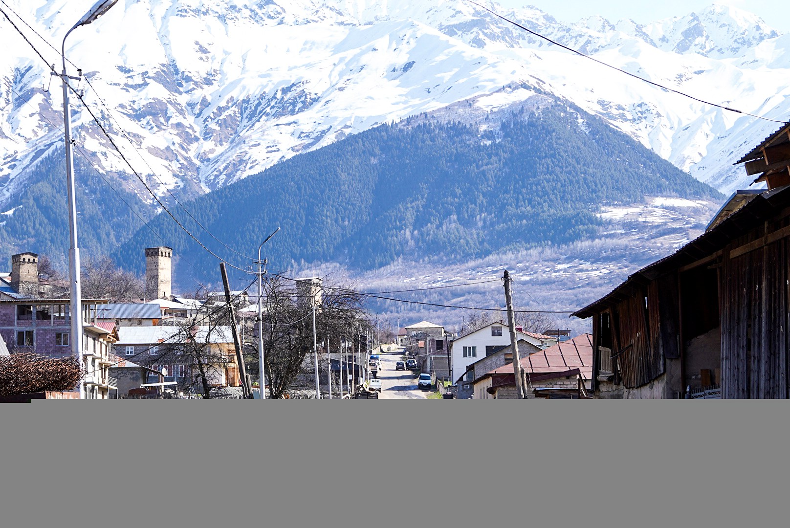 Maisons de svanétie dominées par les versants enneigés, secteur de Mestia, pendant une traversée à ski en Haute-Svanétie.