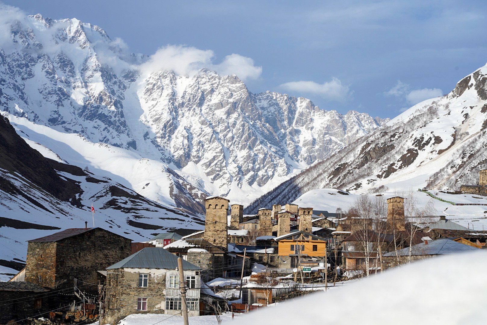 Village de svanétie et tours de pierre devant les sommets enneigés, route de Tbilissi à Mestia et arrivée en Svanétie, pendant le voyage à ski en Géorgie.