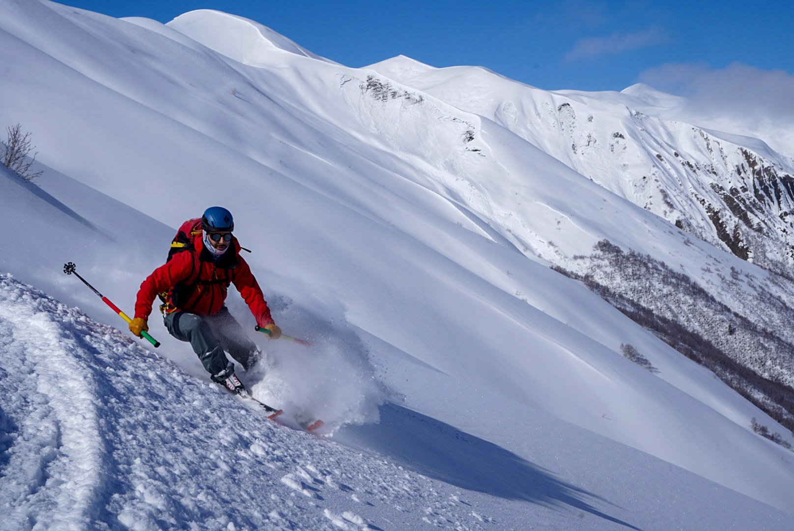 Skieur déclenchant un virage dans la neige légère, secteur d’Adishi et du Tetnuldi, pendant une traversée à ski en Haute-Svanétie.