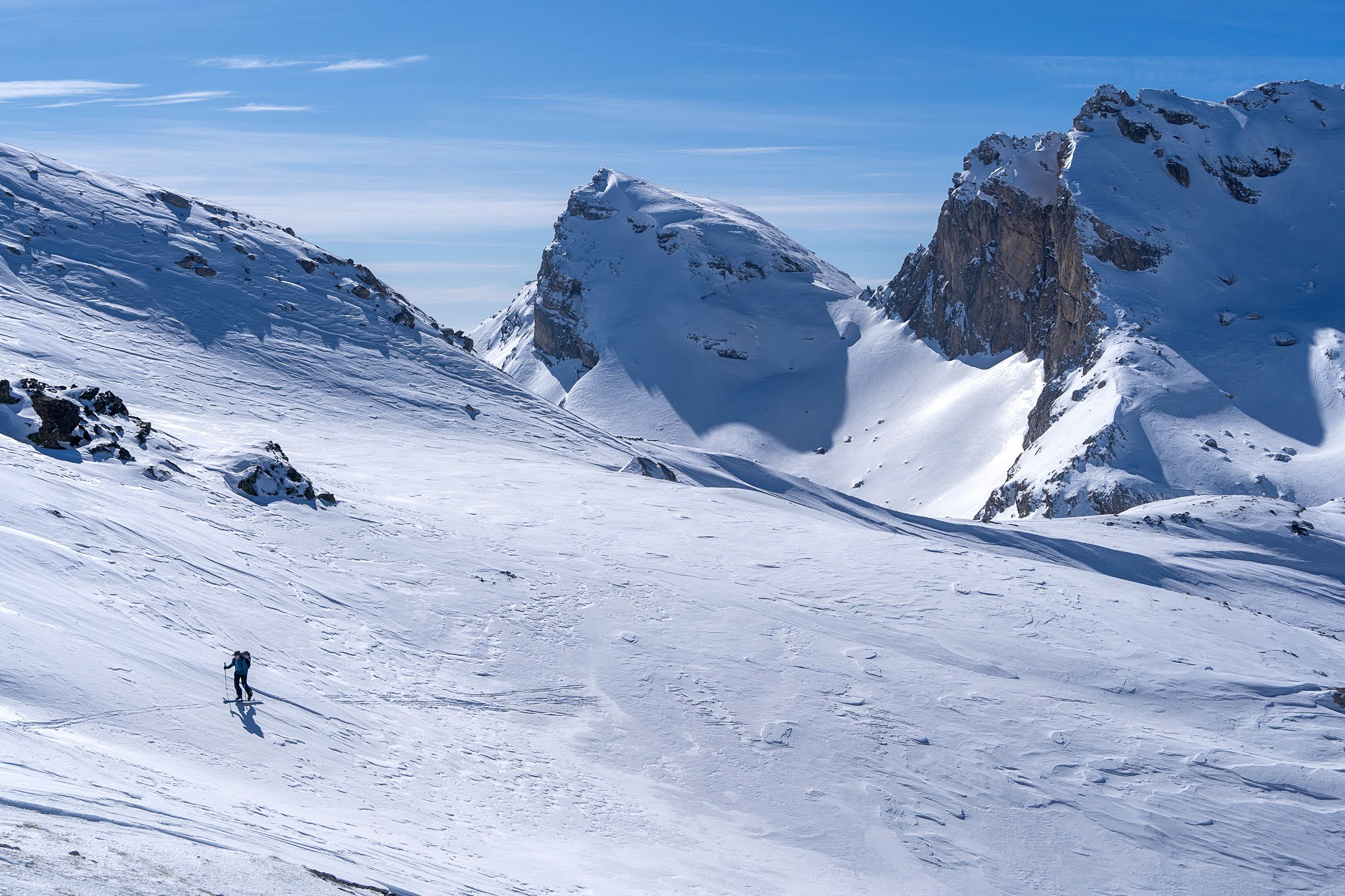 Skieur progressant entre des rochers enneigés, haute vallée de Brod, massif du Šar, pendant une traversée à ski du Kosovo.