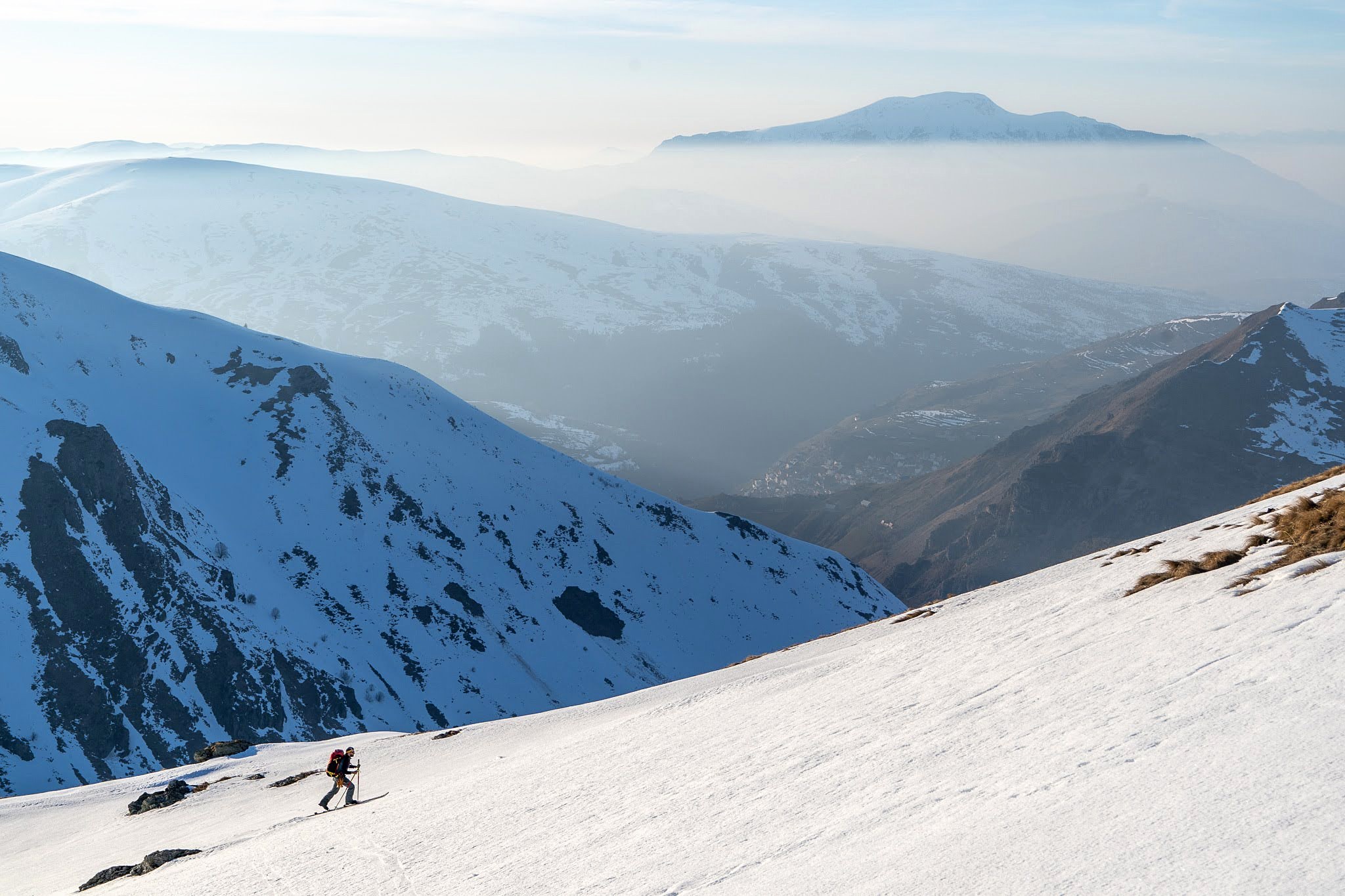 Versants enneigés dominant une mer de brume, haute vallée de Brod, massif du Šar, pendant une traversée à ski du Kosovo.