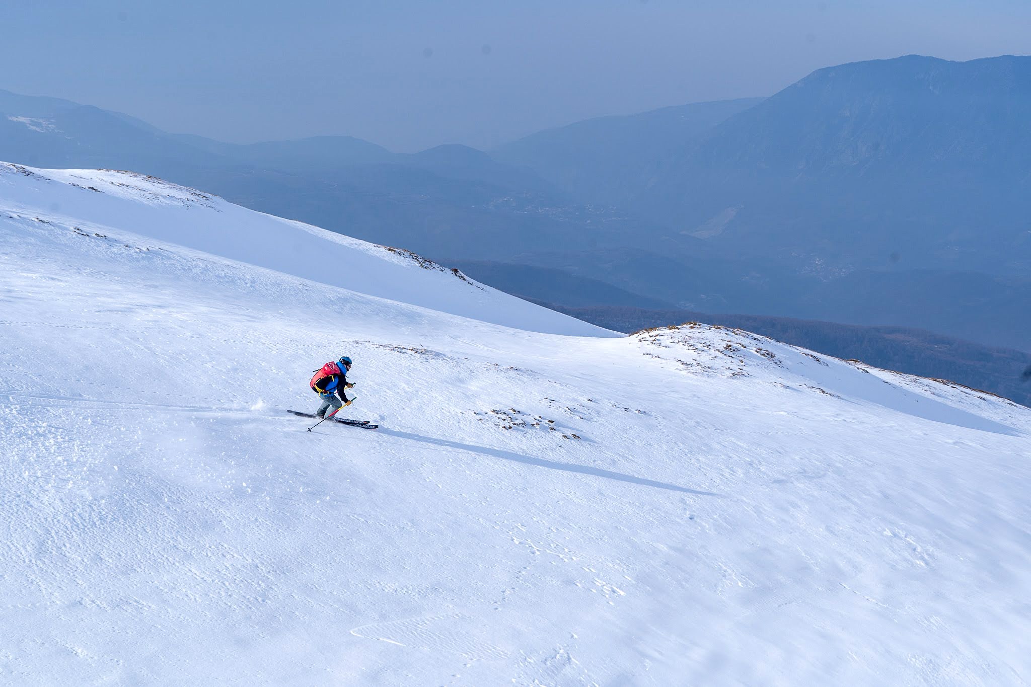 Skieur déclenchant un virage dans la neige légère, secteur de Dragash et Brod, massif du Šar, pendant une traversée à ski du Kosovo.