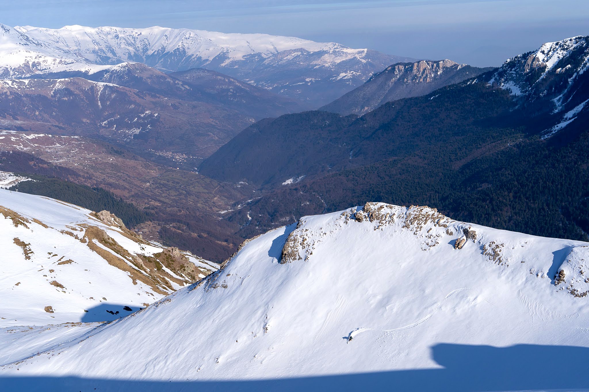 Versant enneigé dominant une vallée boisée, secteur de Dragash et Brod, massif du Šar, pendant une traversée à ski du Kosovo.
