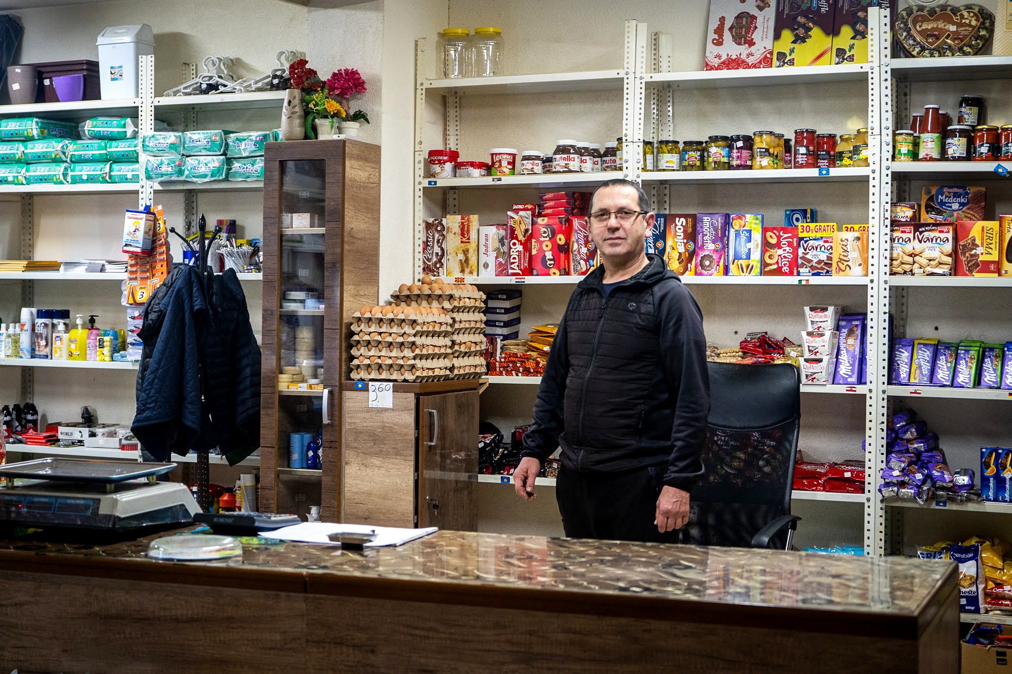 Commerçants derrière le comptoir d’une épicerie de village, haute vallée de Brod, massif du Šar, pendant une traversée à ski du Kosovo.