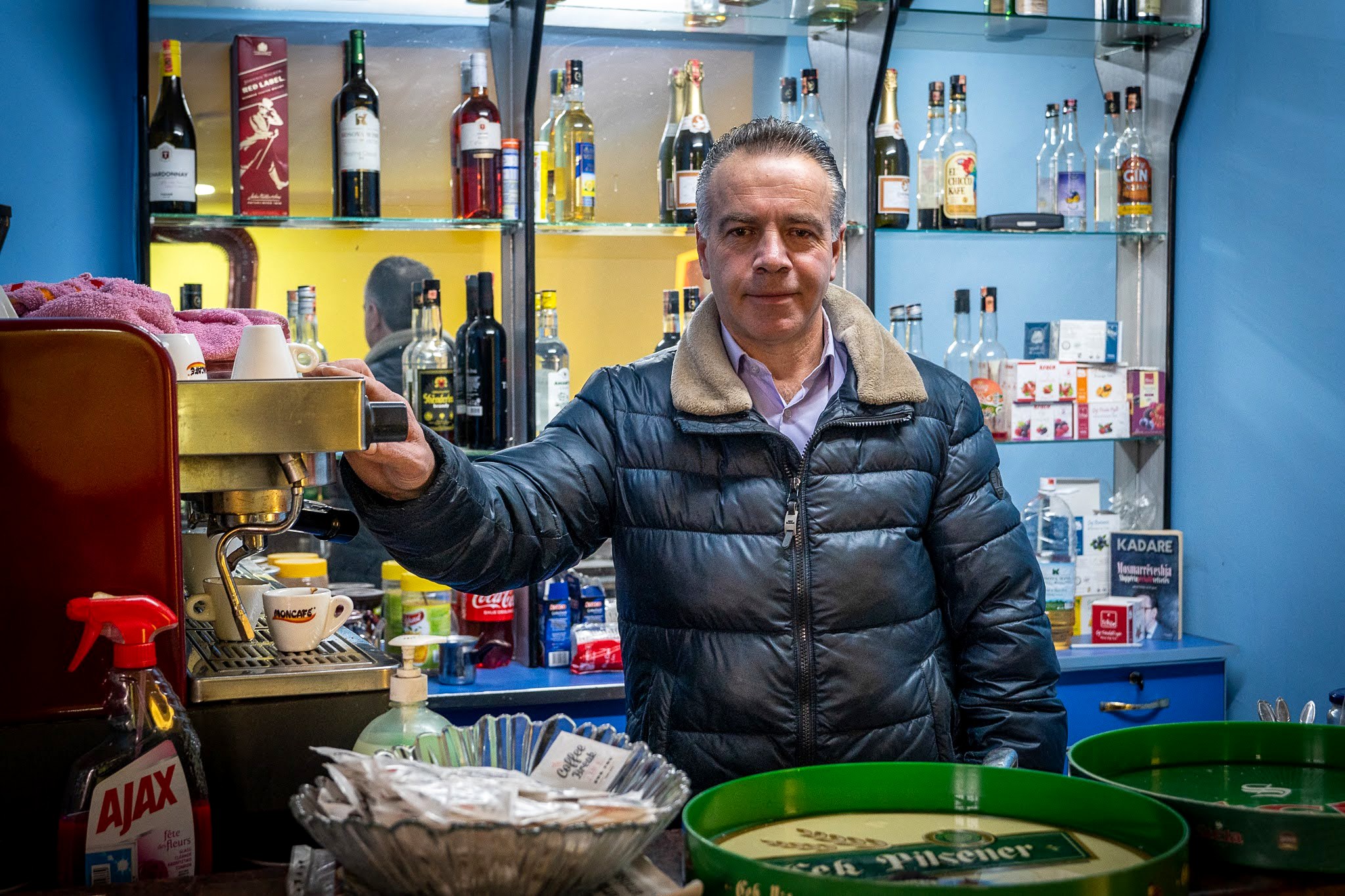 Commerçant levant son verre dans une épicerie locale, secteur occidental du massif du Šar, près du Korab, pendant une traversée à ski du Kosovo.