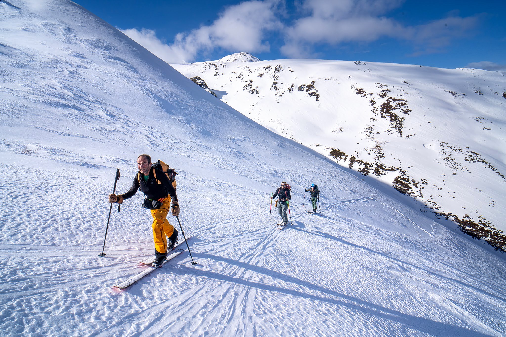 Deux skieurs et un chien suivant la trace, secteur de Prevalla, parc national des monts Šar, pendant une traversée à ski du Kosovo.