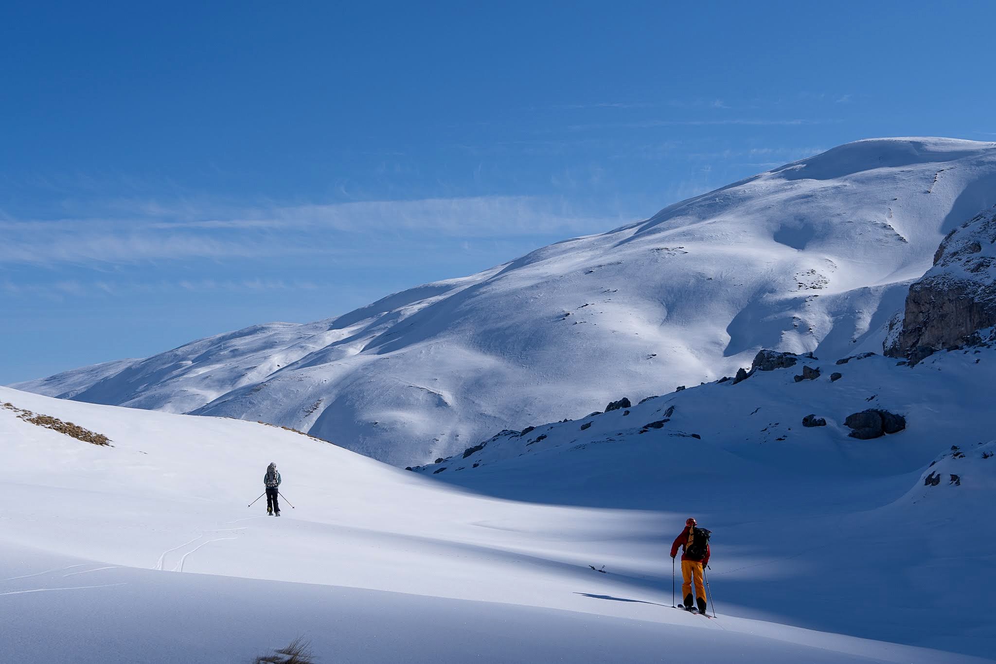 Skieur avançant seul entre les ondulations de neige, haute vallée de Brod, massif du Šar, pendant une traversée à ski du Kosovo.