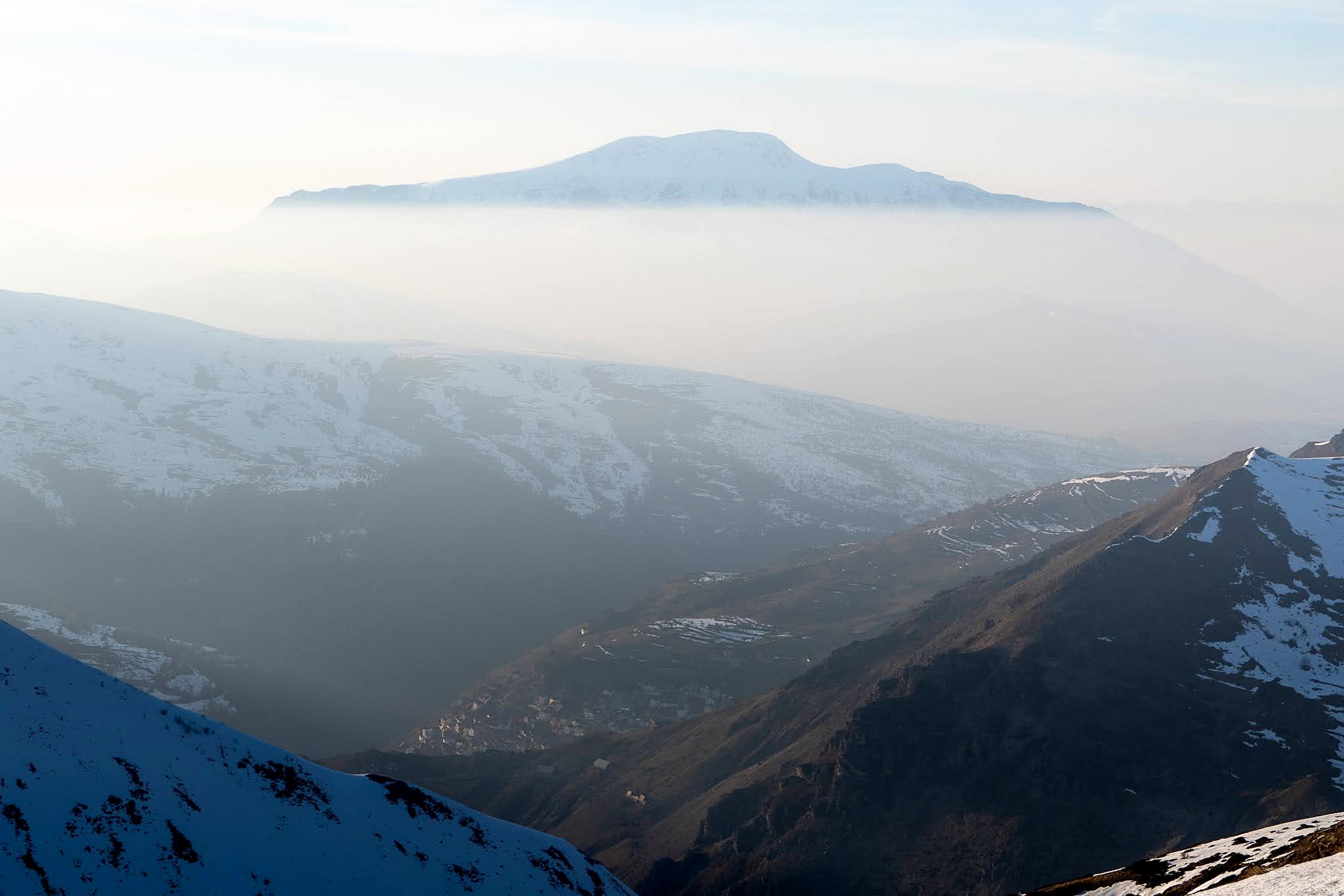 Vallée profonde et reliefs superposés dans la brume, haute vallée de Brod, massif du Šar, pendant une traversée à ski du Kosovo.