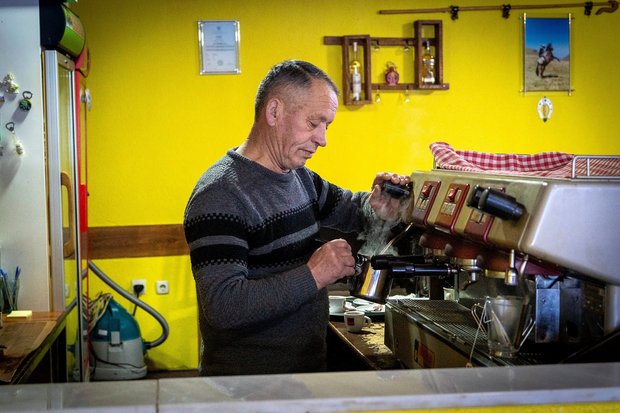 Hôte préparant le repas dans une pièce colorée, haute vallée de Brod, massif du Šar, pendant une traversée à ski du Kosovo.