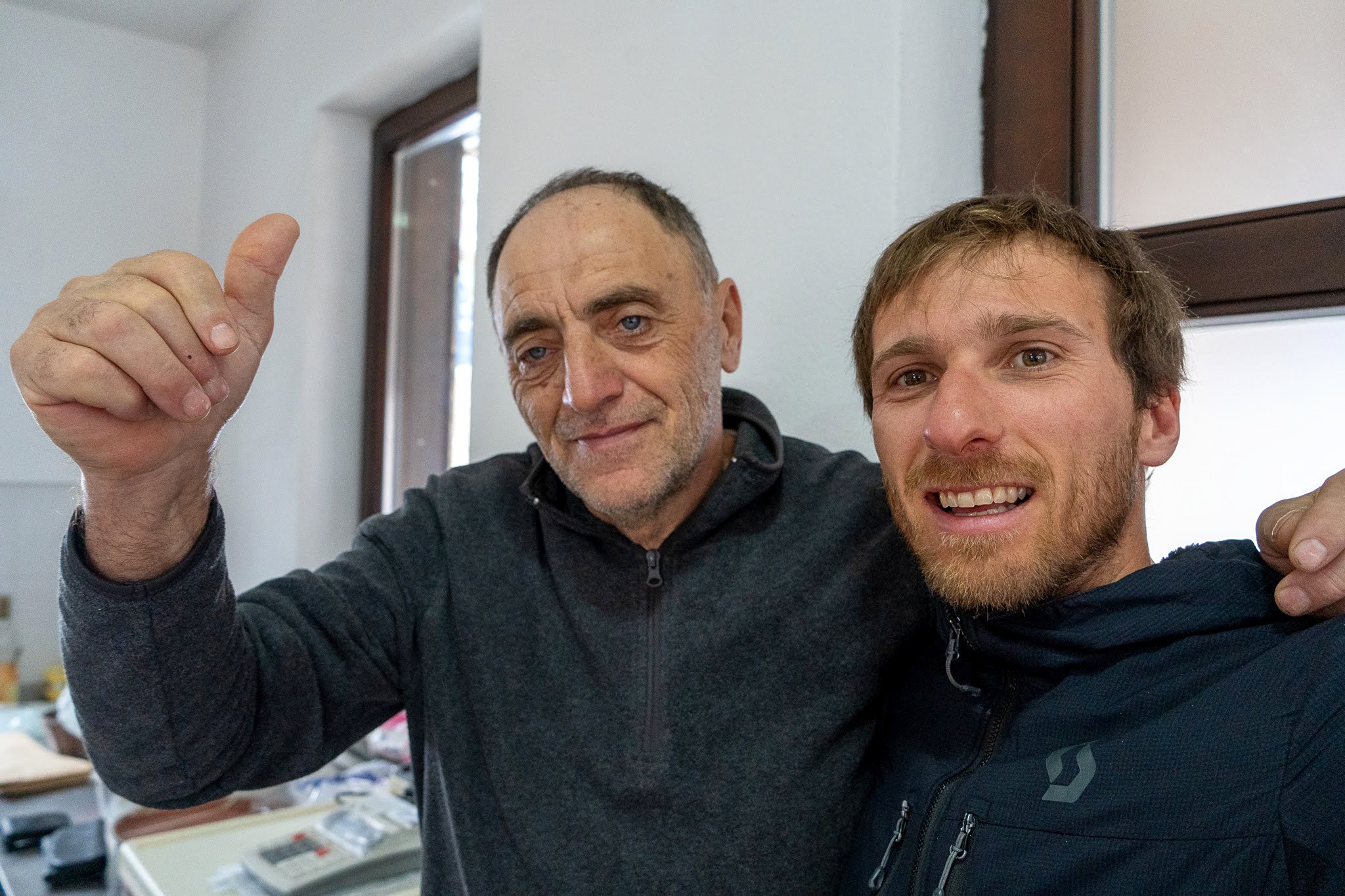Voyageur et habitant souriant face à l’objectif, secteur occidental du parc national des monts Šar, pendant une traversée à ski du Kosovo.