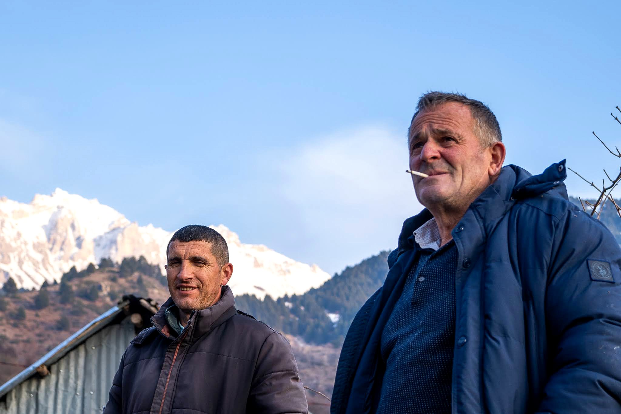 Deux habitants photographiés devant les montagnes, secteur occidental du massif du Šar, près du Korab, pendant une traversée à ski du Kosovo.