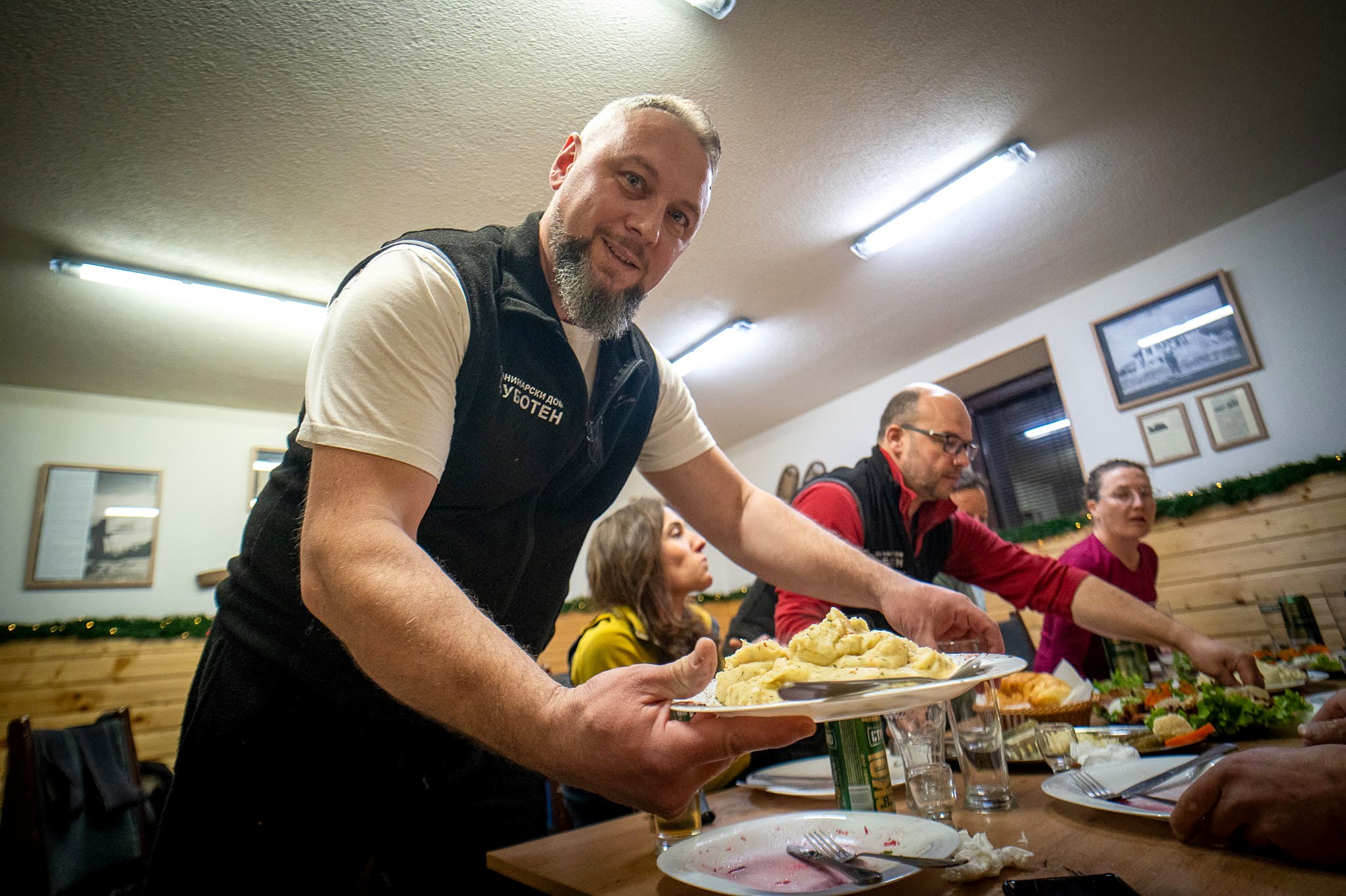 Groupe partageant un grand repas dans la guesthouse, secteur oriental des monts Šar, vers le Ljuboten, pendant une traversée à ski du Kosovo.