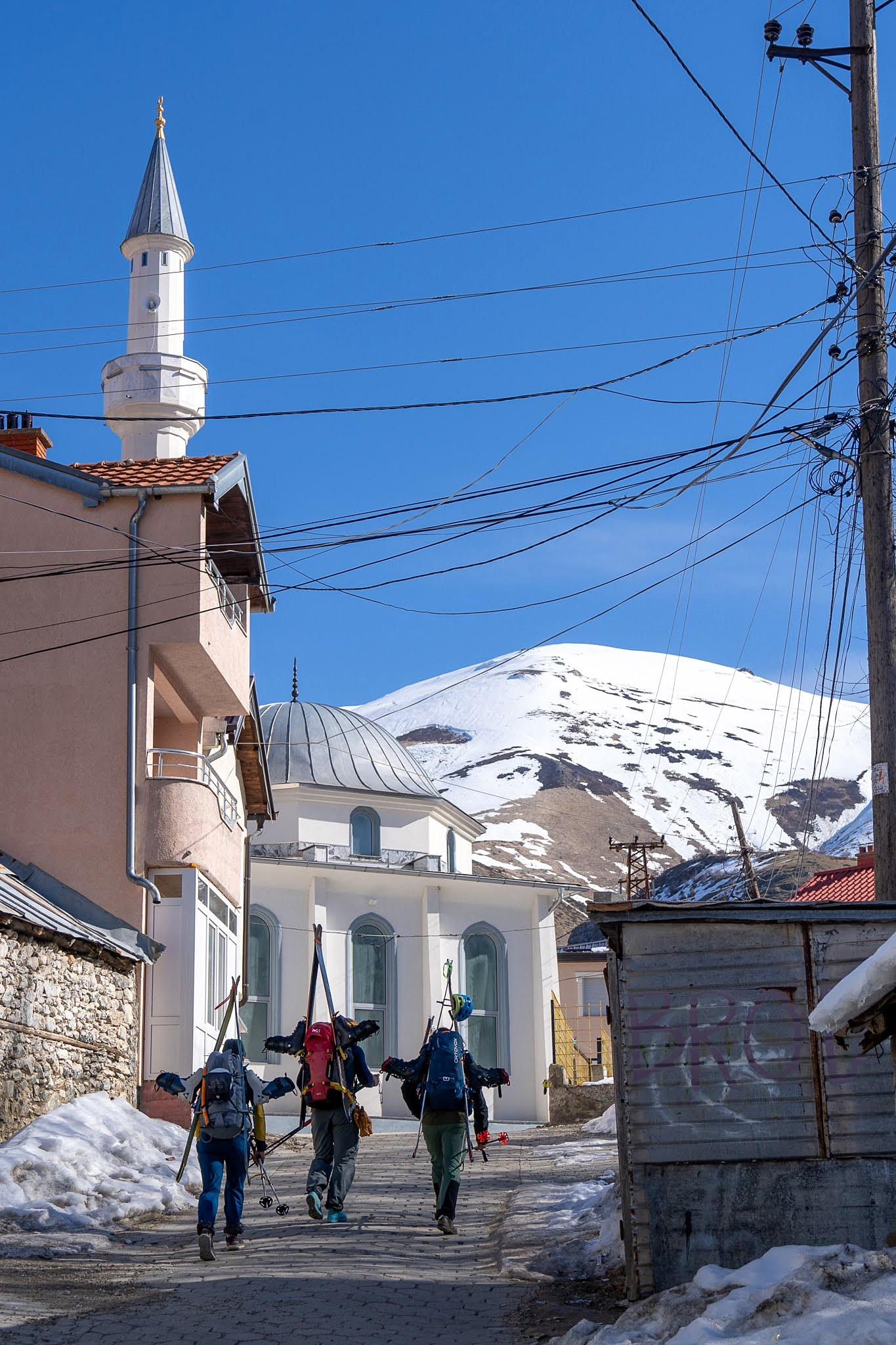 Rue enneigée menant au minaret du village, haute vallée de Brod, massif du Šar, pendant une traversée à ski du Kosovo.