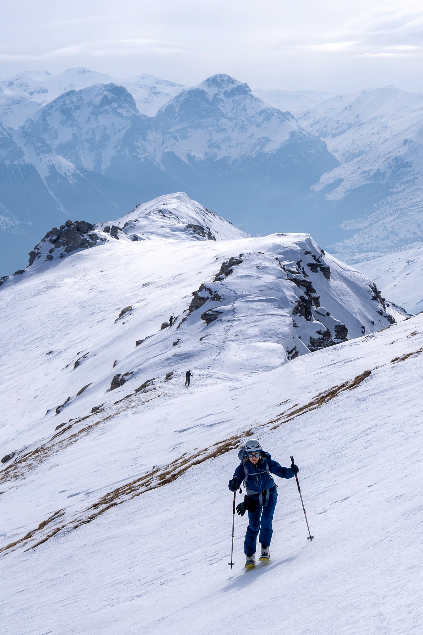 Skieur montant au pied d’un relief rocheux, secteur de Dragash et Brod, massif du Šar, pendant une traversée à ski du Kosovo.