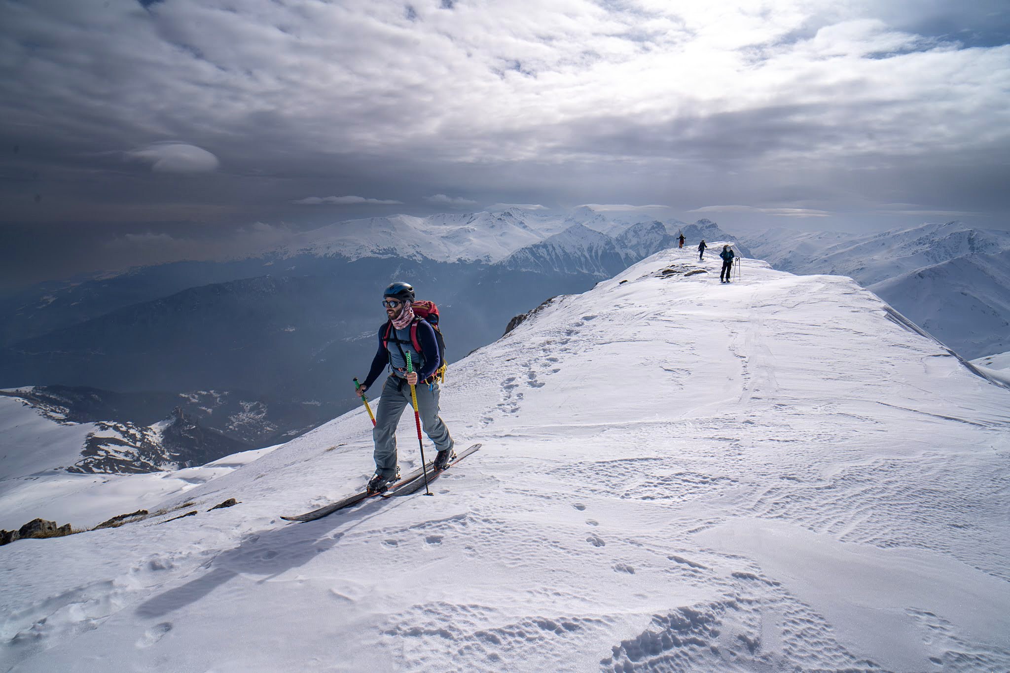 Skieur progressant sur une arête balayée par le vent, secteur de Dragash et Brod, massif du Šar, pendant une traversée à ski du Kosovo.