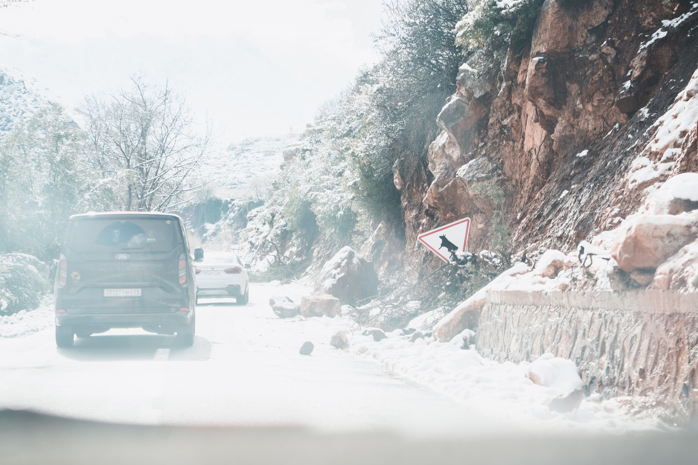 Route et village sous la neige dans le massif du Toubkal, Haut Atlas marocain