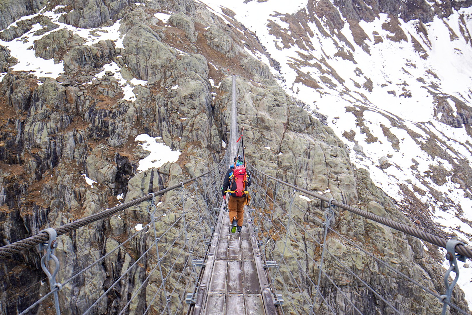Traversée d’une passerelle suspendue pendant la traversée Dammastock–Titlis dans les Alpes suisses, au jour 2 de l’itinérance.