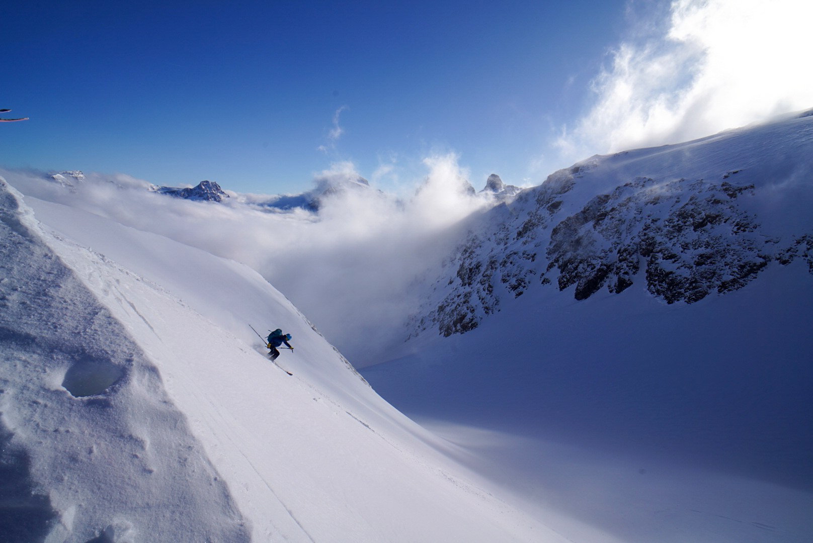 Descente à ski entre les nuages pendant la traversée Dammastock–Titlis dans les Alpes suisses, au jour 4 de l’itinérance.