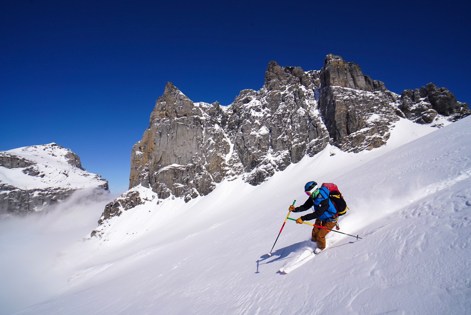 Descente sous les tours rocheuses pendant la traversée Dammastock–Titlis dans les Alpes suisses, au jour 4 de l’itinérance.