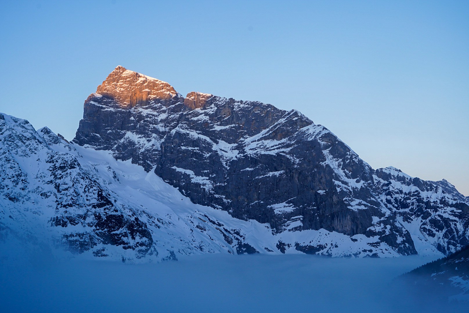 Alpenglow sur un sommet rocheux pendant la traversée Dammastock–Titlis dans les Alpes suisses, au jour 5 de l’itinérance.