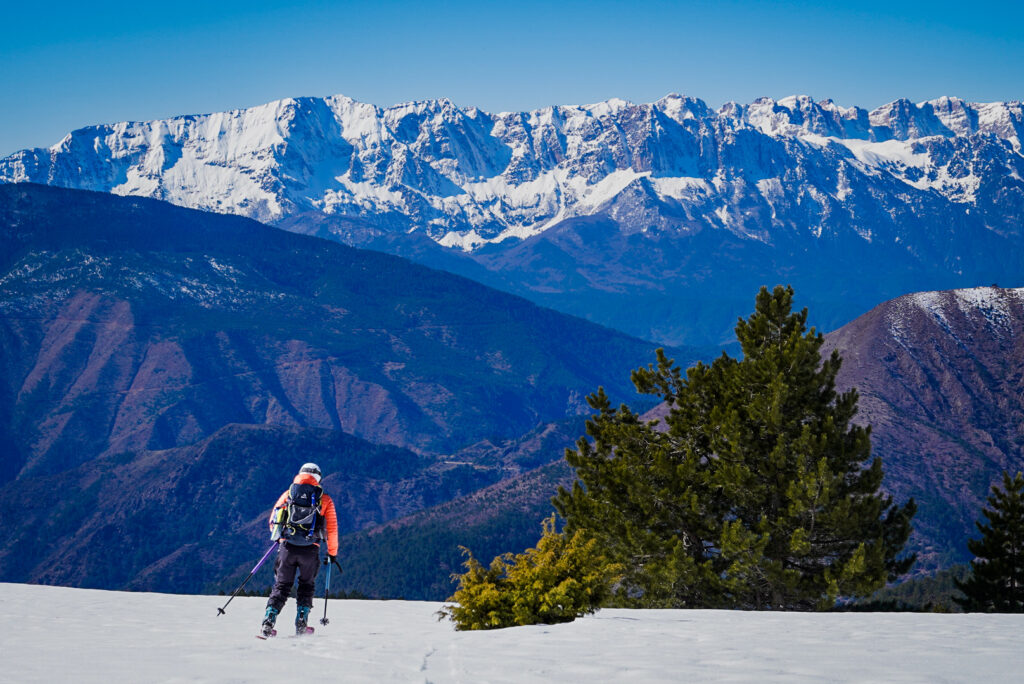 Descente à ski vers Samarina dans les montagnes du Pinde en Grèce, face aux sommets enneigés des Prokletije